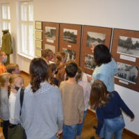 Uczniowie ogladają wystawę zdjęć runku w Kaźmierzu