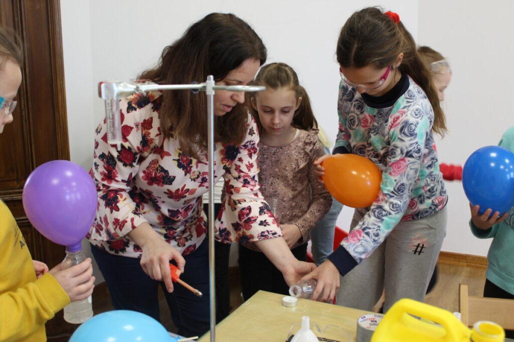 Ferie zimowe 2023 - grupa dzieci i ich opiekunowie - zajęcia chemiczne z balonami