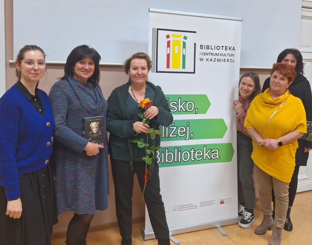 6 kobiet stoi w budynku przy banerze Projekt Blisko Bliżej Biblioteka
