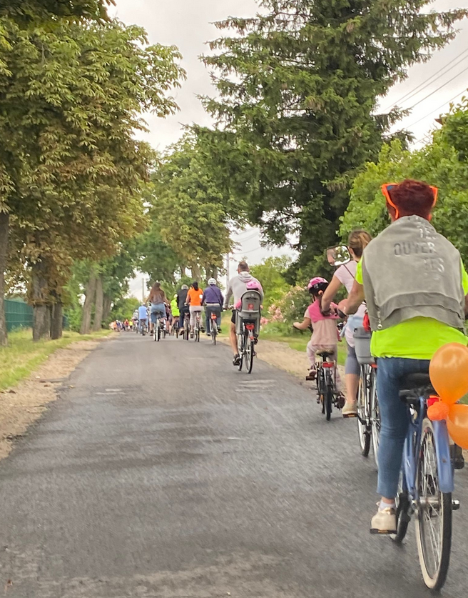 droga rajd rowerowy ludzie jadą na rowerach pomarańczowe balony 