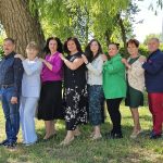 8 osób na dworze pod drzewem
