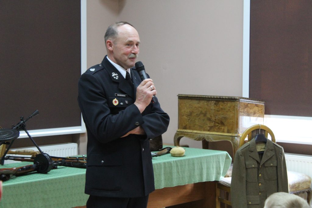 W budynku, mężczyzna w mundurze z mikrofonem - prelekcja z okazji 80. rocznicy zakończenia II wojny światowej
