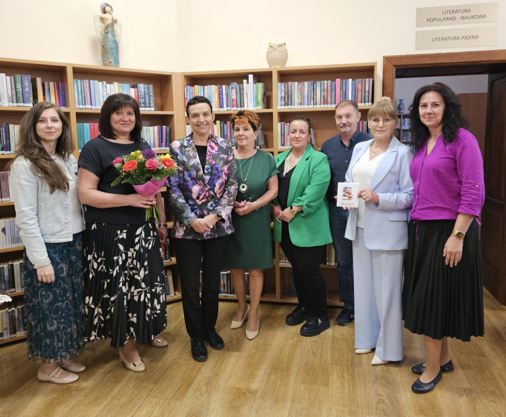 w budynku na tle książek w bibliotece 8 osób