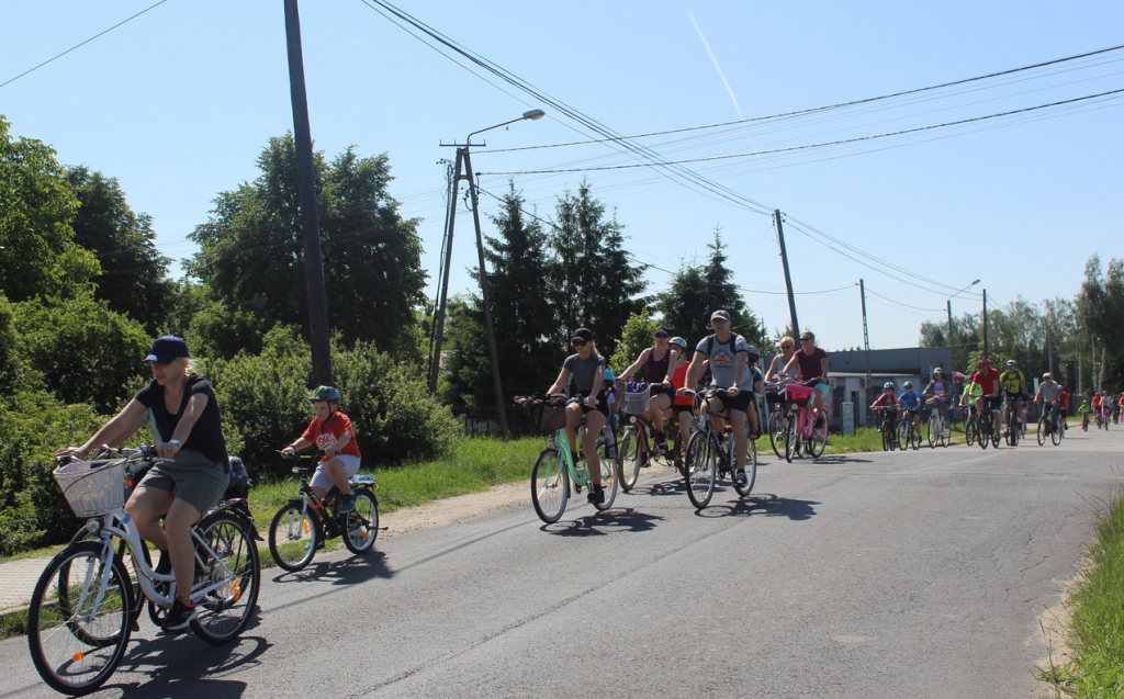 na świeżym powietrzu, droga asfaltowa ludzie jadą na rowerach