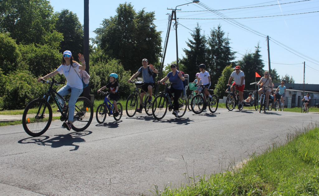 na świeżym powietrzu, droga asfaltowa ludzie jadą na rowerach
