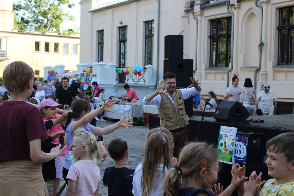 Iluzjonista, pokaz, w parku przed pałacem, grupa ludzi pod sceną 
