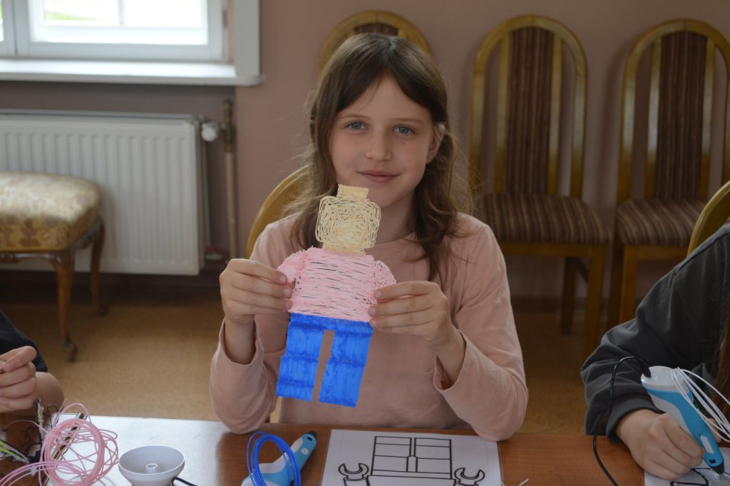 warsztaty długopis 3D dziewczynka pokazuje swoją prace narysowanego długopisem 3d ludzika Lego