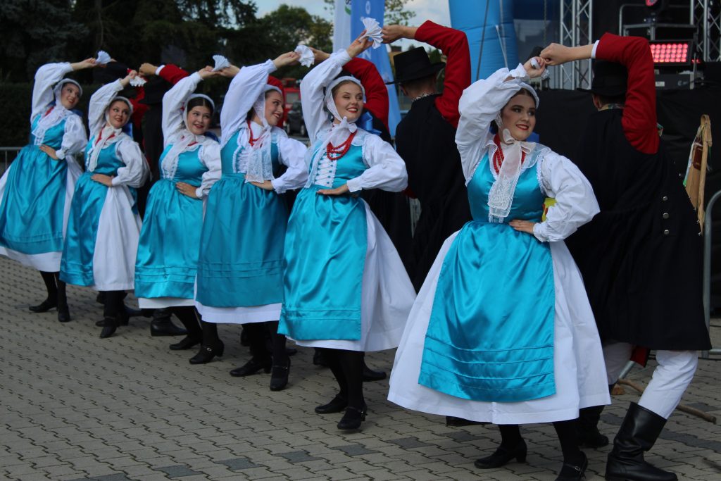 Zespół folklorystyczny tańczy przed sceną