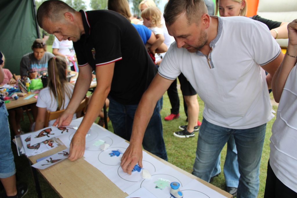 ludzie przy stoisku rozwiązują zagadki logiczne