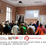 Anna Łubieńska spotkanie wykład Prelegentka mówi do zgromadzonych w sali ludzi logo instytucji napis Dofinansowano ze środków Muzeum Historii Polski w Warszawie w ramach programu „Patriotyzm Jutra”