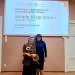 dwie kobiety stoją na środku spotkanie prelekcja Wandy Niegolewskiej prezentacja Plansza z belką Historia i Dziedzictwo Kaźmierskich Kobiet Kontakt i informacje: 61 29 18 072 Pałac, ul. NOWOWIEJSKA 15, Kaźmierz Dofinansowano ze środków Muzeum Historii Polski w Warszawie w ramach programu „Patriotyzm Jutra”