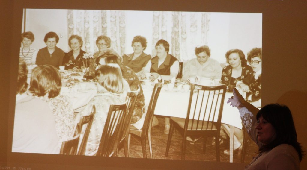 Wyświetlone zdjęcia z rzutnika kobieta pokazuje osoby na fotografii