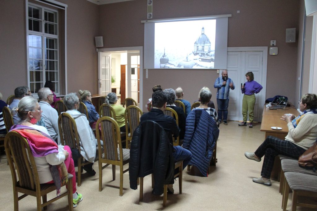 spotkanie z podróżnikiem grupa ludzi w sali prezentacja i prelegentka