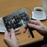 zdjęcie w rękach lupa stół i herbata w filiżance