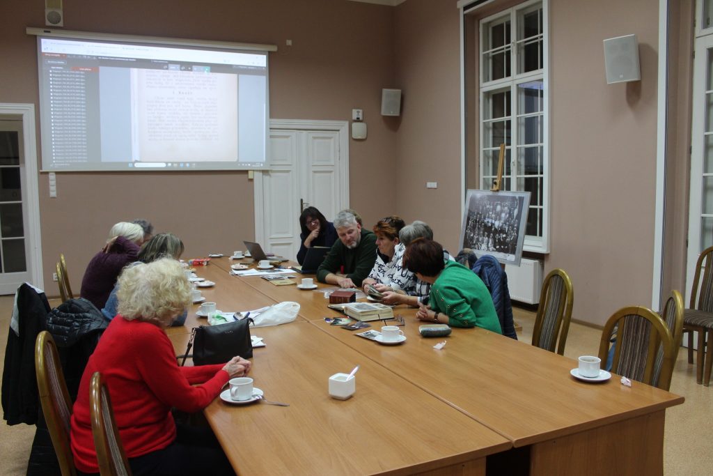 Przy nakrytym stole siedzi 11 osób