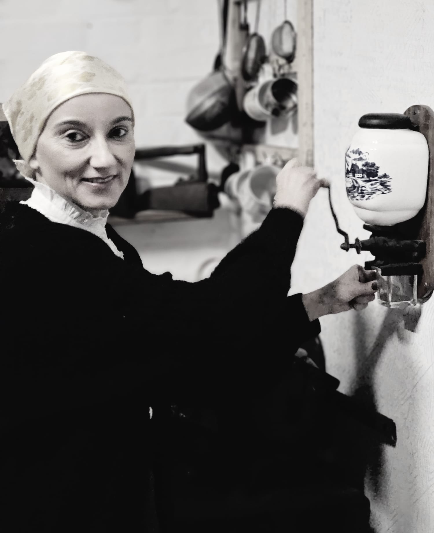 Kobieta przy młynku z kawą zdjęcie stylizowane na stare