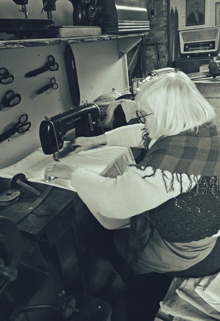 Kobieta przy maszynie do szycia zdjęcie stylizowane na stare