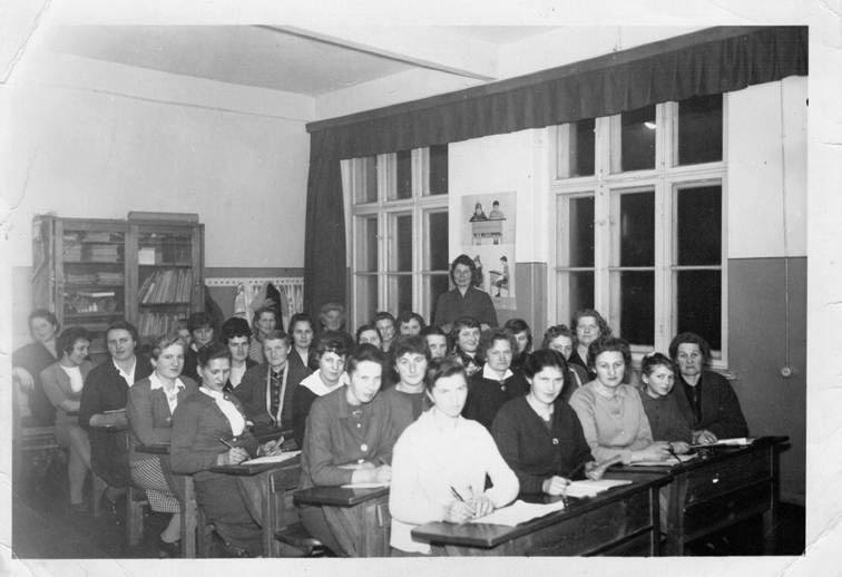 Grupa kobiet w szkolnych ławkach - stare zdjęcie czarno-białe podpis KGW Radzyny, kurs w budynku szkoły w Radzynach