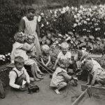 Dzieci przychodzące w wakacje do sióstr wraz z s. Vianeyą Lipińską, 1963 r. szóstka dzieci i siostra zakonna w ogrodzie czarno-białe zdjęcie