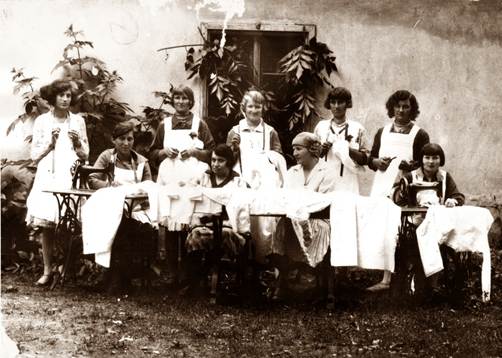 Kurs szycia 1933
grupa kobiet pozuje do zdjęcia przed nimi maszyny do szycia
zdjęcie stare czarno-białe