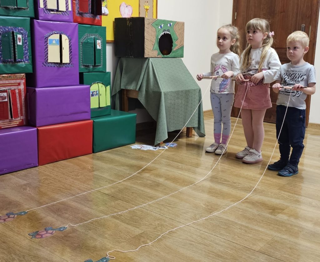 Zabawa w wyścigi, trójka dzieci w sali