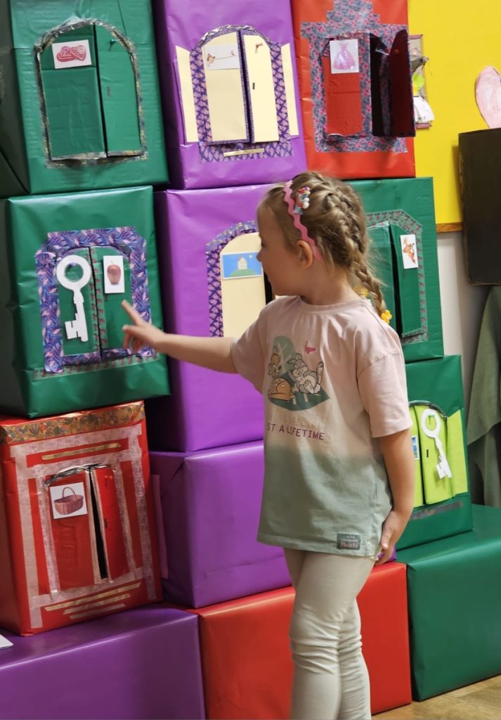 Dziecko wskazuje na kolorowe pudła