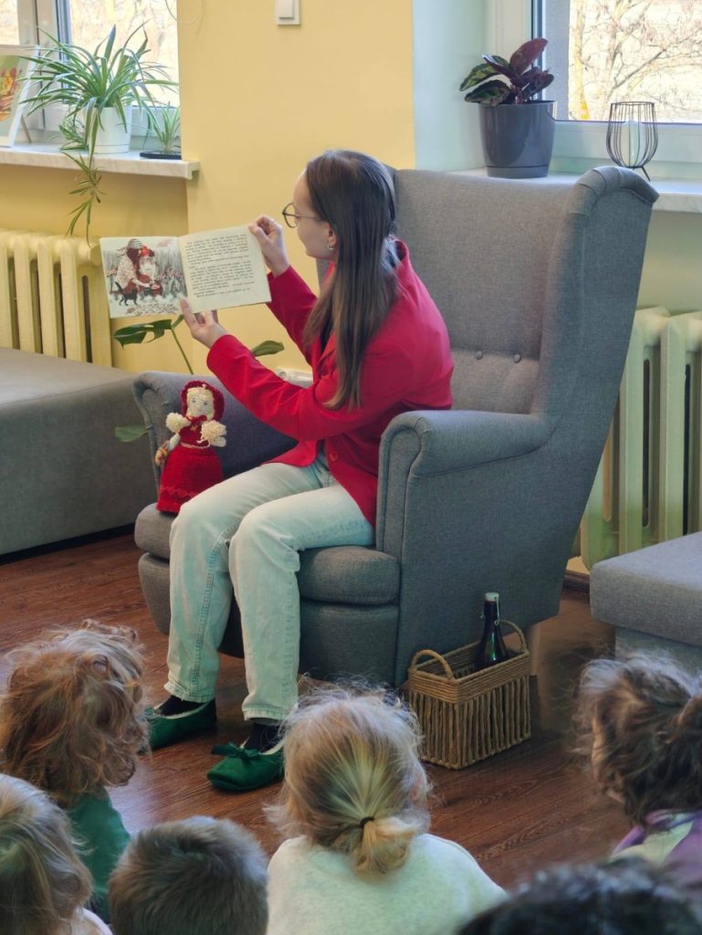 Kobieta pokazuje dzieciom książkę