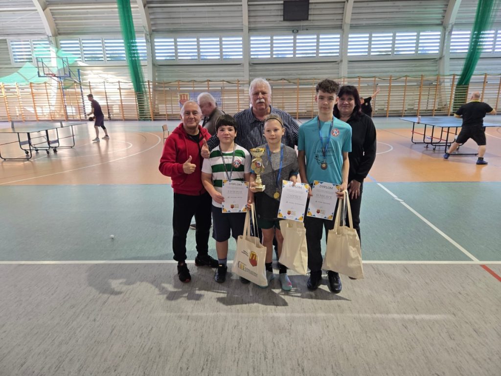 trzech chłopców z nagrodami i 3 dorosłe osoby dwóch mężczyzn i kobieta w sali gimnastycznej