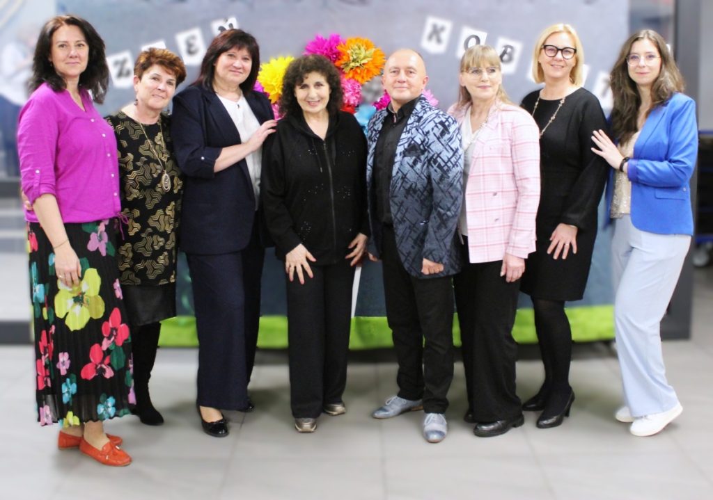 8 osób pozuje do zdjęcia szyld dzień kobiet