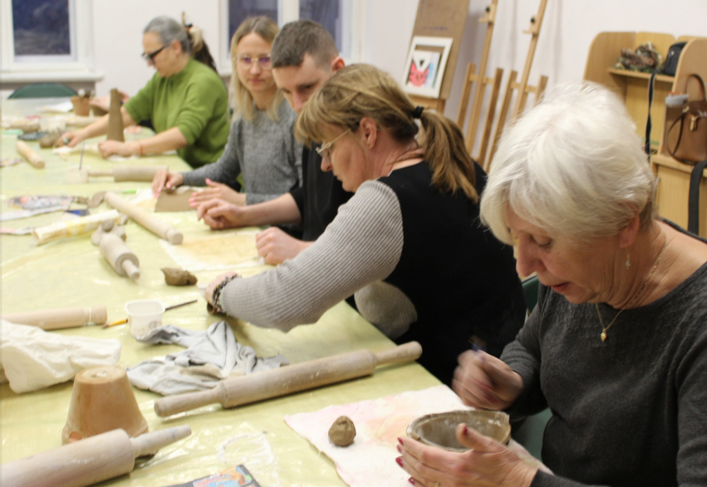 grupa ludzi pracuje przy stołach, ceramika, w pomieszczeniu
