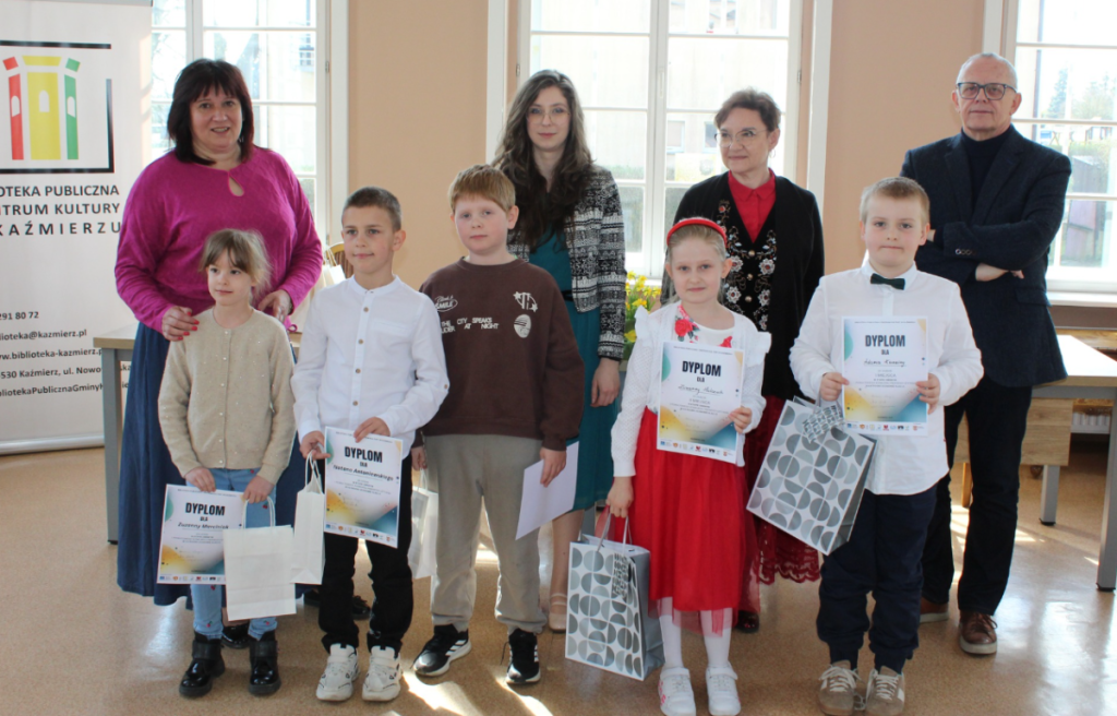 grupa ludzi dorośli i młodzież pamiątkowe zdjęcie z uczestnikami konkursu, dyplomy i nagrody