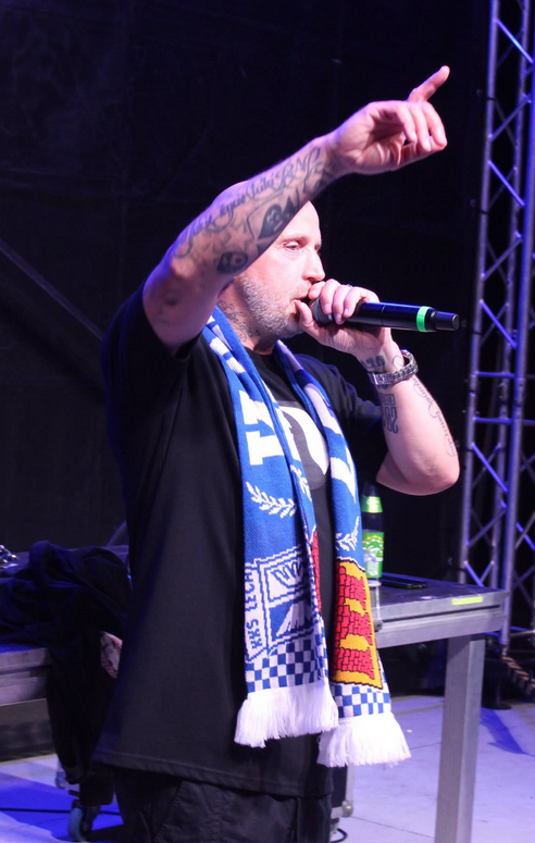 Mężczyzna na scenie z szalikiem Lecha